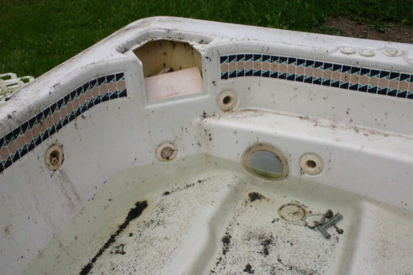 Old dirty hot tub without water, should be removed and replaced